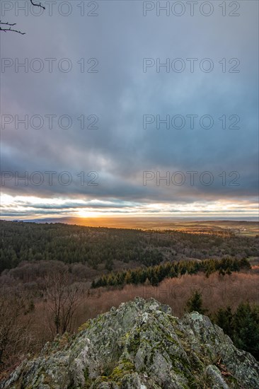 Landscape at the Grosser Zacken, Taunus volcanic region. A cloudy, sunny autumn day, meadows, hills, fields and forests with a view of the sunset. Hesse, Germany, Europe