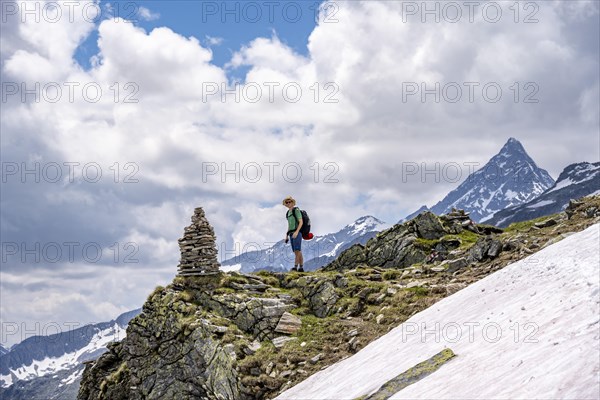 Mountaineer on a rocky hiking trail with cairns, Berliner Hoehenweg, mountain landscape with Schrammacher peak, Zillertal Alps, Tyrol, Austria, Europe