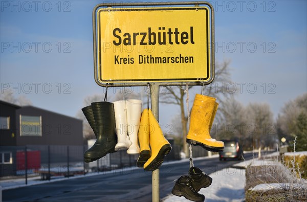 Town sign with rubber boots, protest by farmers in Sarzbuettel, Dithmarschen, Schleswig-Holstein, Germany, Europe