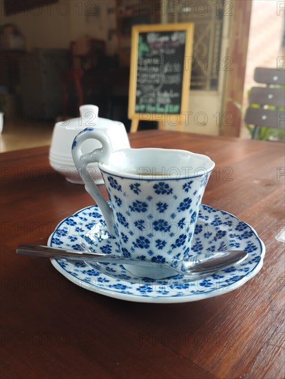 An elegant porcelain cup and saucer in a nostalgic vintage themed cafe, autumnal aesthetic