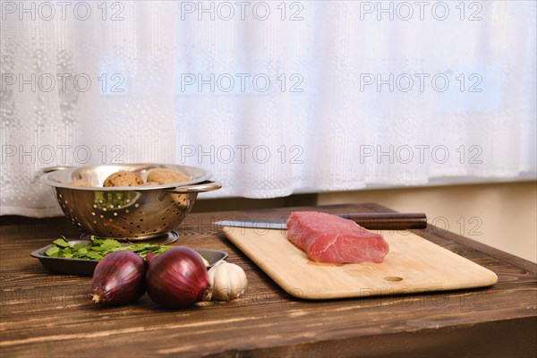 Raw ingredients for pork ragout on rustic wooden table