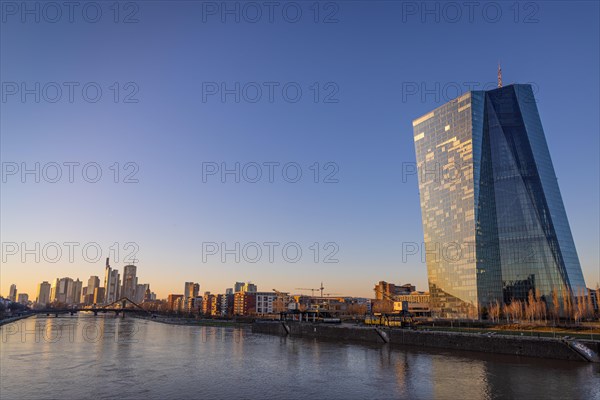 The light of the setting winter sun falls sideways on the buildings of the European Central Bank (ECB) and the Frankfurt banking skyline, Frankfurt am Main, Hesse, Germany, Europe