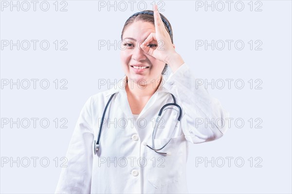 Cheerful female doctor gesturing approval isolated. Young female doctor approving with finger on isolated background