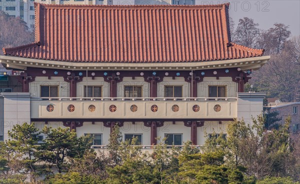 Daejeon, South Korea, March 13, 2017: Building with classical oriental styling with red clay tiled roof, metal mesh windows and intricate designs in the wall of the portico, Asia