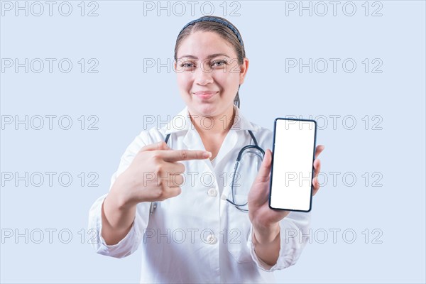 Female doctor showing and pointing an advertisement on the smartphone screen isolated. Smiling female doctor pointing an app on the phone screen