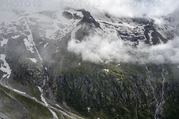 Snow-covered cloudy mountains with Pfitscher ridge and glacier Roetkees, mountain streams as waterfalls on a mountain slope, Furtschaglhaus, Berliner Hoehenweg, Zillertal, Tyrol, Austria, Europe