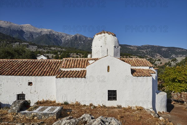 Church of St Michael the Archangel, Cross-domed church, White church architecture against a background of mountains and blue sky, Aradena Gorge, Aradena, Sfakia, Crete, Greece, Europe