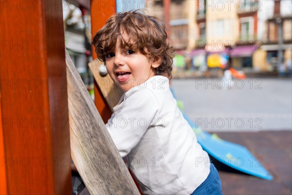 Close-up of a happy girl looking at camera before going up a slide in a playground