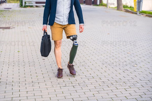 Lower part of an unrecognizable and informal businessman with prosthetic leg walking in the city