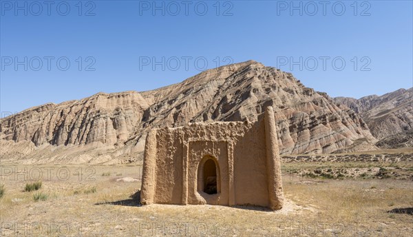 Clay mausoleum, tombstones, old Kyrgyz cemetery, between dry eroded landscape, Naryn region, Kyrgyzstan, Asia