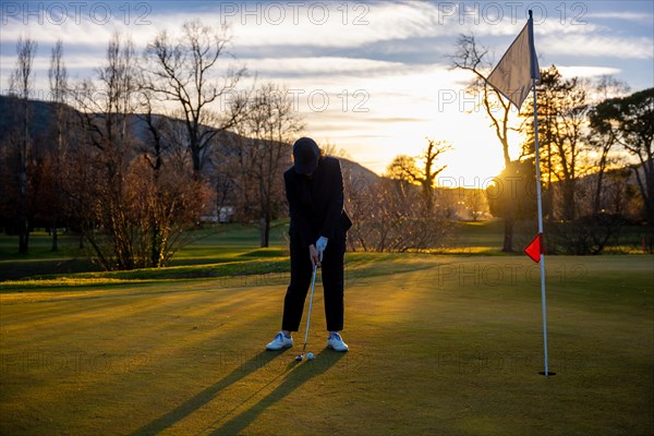 Female Golfer Concentration on the Putting Green on Golf Course in Sunset in Switzerland