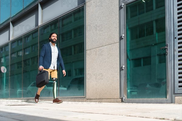 Photo with copy space of a businessman with prosthetic leg walking along a financial district street