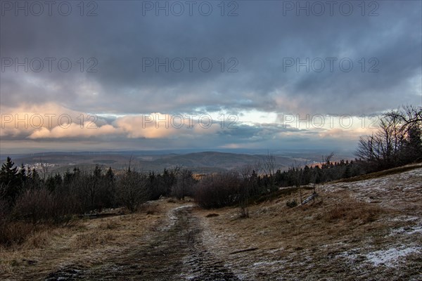 Landscape on the Grosser Feldberg, Taunus volcanic region. A cloudy, sunny winter day, meadows, hills, snow and forests with a view of the winter sunset. Hesse, Germany, Europe