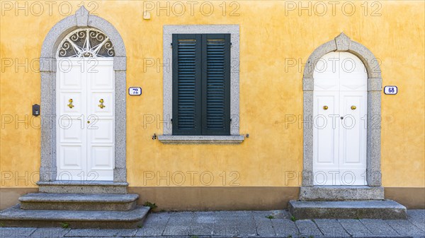 White arched front doors in pastel-coloured house wall, Sant'ilario in Campo, Elba, Tuscan Archipelago, Tuscany, Italy, Europe