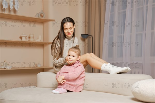A Serene woman and baby on a white couch, enjoying a quiet moment