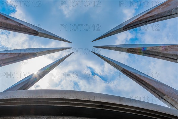 Curved, pointed spires of building reaching into beautiful partly cloudy blue sky