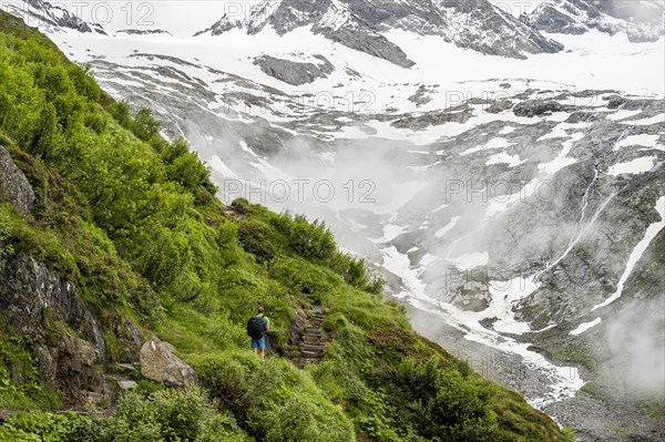 Mountaineers on a hiking trail, Schlegeiskees glacier in the background, cloudy and atmospheric mountain landscape, ascent to Furtschaglhaus, Berliner Hoehenweg, Zillertal, Tyrol, Austria, Europe