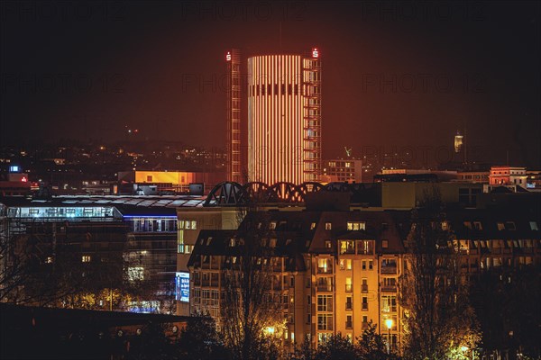 Illuminated skyscraper dominates the cityscape at night under an orange-red sky, Sparkasse Tower, Pforzheim, Germany, Europe