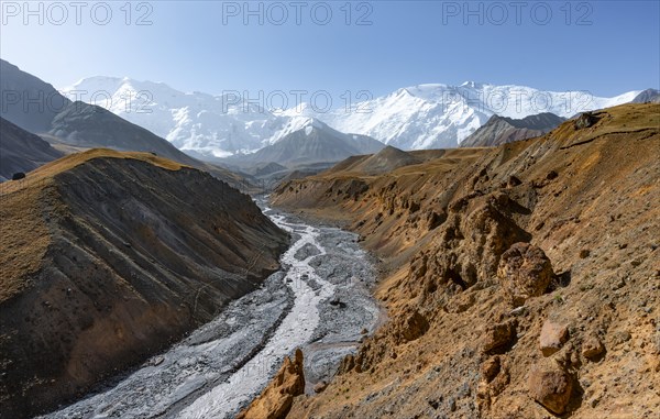 Achik Tash river, Achik Tash valley with rock formations, behind glaciated and snow-covered mountain peak Pik Lenin, Trans Alay Mountains, Pamir Mountains, Osh Province, Kyrgyzstan, Asia