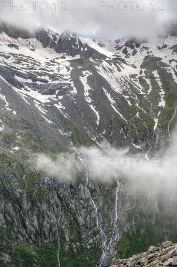 Snow-covered cloudy mountains, mountain streams as waterfalls on a mountain slope, Furtschaglhaus, Berliner Hoehenweg, Zillertal, Tyrol, Austria, Europe