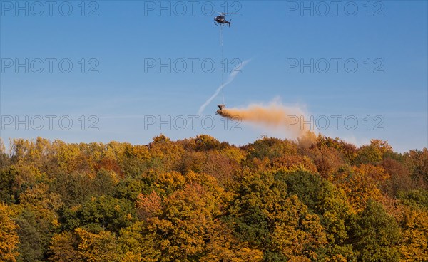 Helicopter fertilising over a wooded area, Osterholz, Wuppertal, North Rhine-Westphalia, Germany, Europe
