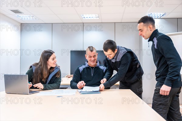 Group of workers and engineers in a cnc factory in a meeting room