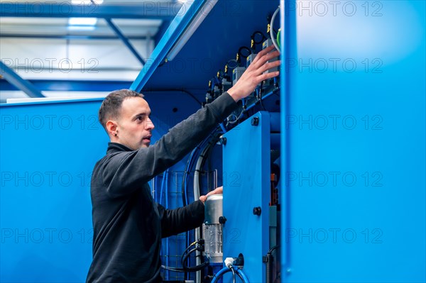 Industrial technician installing and maintenance electrical mechanical systems in a factory
