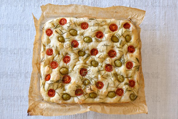 Homemade Italian flatbread Focaccia with cherry tomatoes, olives and rosemary