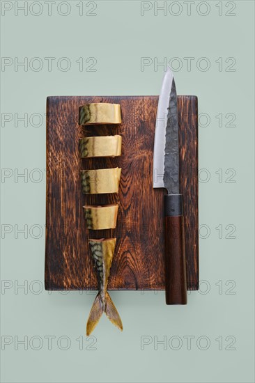 Overhead view of sliced smoked mackerel in a wooden cutting board