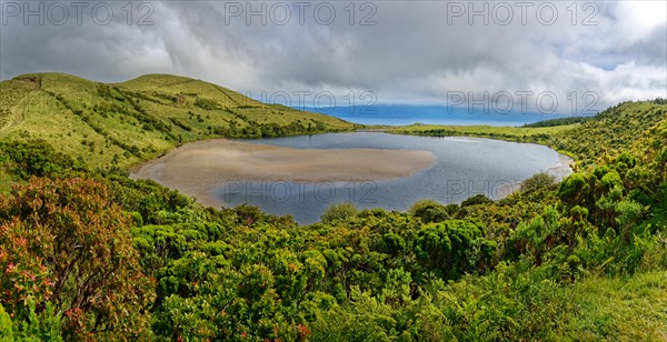 Lake and volcanic crater Lagoa do Caiado surrounded by green hills and clouds, Estradas dos Lagoas, Madalena, Pico, Azores, Portugal, Europe
