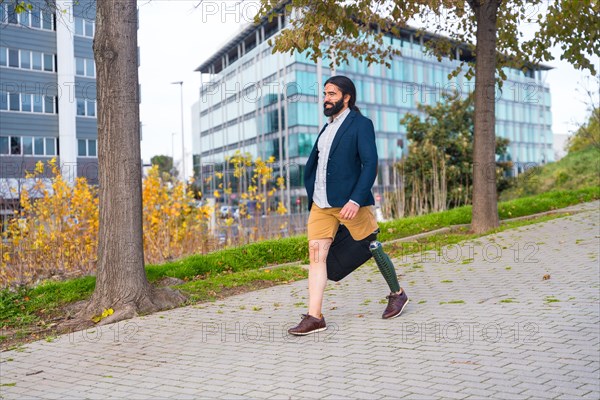 Photo with copy space of a businessman with amputee leg walking along an urban park