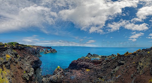 Dramatic view of a coastline lined with volcanic rocks under a clear sky, lava rocks coastal walk Ponta da Iiha, Calhau, west coast, Pico, Azores
