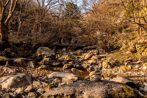 Pebble stack on boulder in dry riverbed in mountain wilderness park