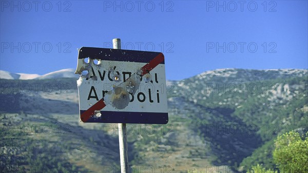 A damaged road sign with bullet holes, in the background a picturesque mountain landscape, Anopolis, Sfakia, West Crete, Crete, Greece, Europe