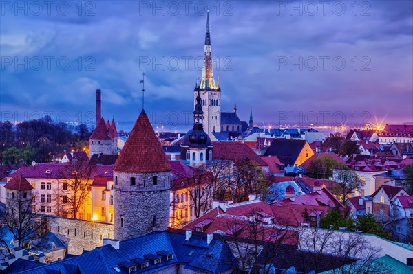 Aerial view of Tallinn Medieval Old Town with St. Olaf's Church and Tallinn City Wall illuminated in evening, Estonia, Europe