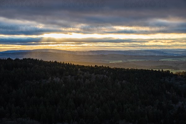 Landscape at the Grosser Zacken, Taunus volcanic region. A cloudy, sunny autumn day, meadows, hills, fields and forests with a view of the sunset. Hesse, Germany, Europe