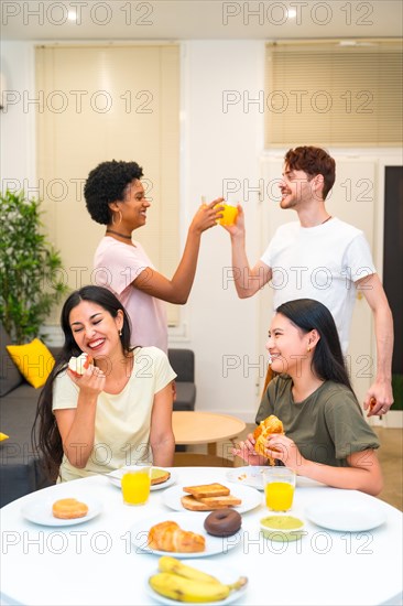 Vertical photo of a group of multi-ethnic friends enjoying and celebrating while eating breakfast at home