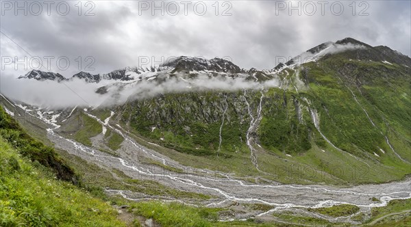 Cloudy valley of Schlegeisgrund with mountain stream, glaciated mountain peaks Hoher Weiszint and Hochsteller, Berliner Hoehenweg, Zillertal, Tyrol, Austria, Europe