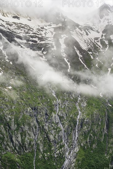 Snow-covered cloudy mountains, mountain streams as waterfalls on a mountain slope, Furtschaglhaus, Berliner Hoehenweg, Zillertal, Tyrol, Austria, Europe