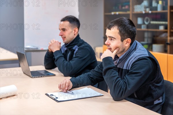 Engineers concentrated during a meeting in a meeting room of a logistics and machinery construction factory