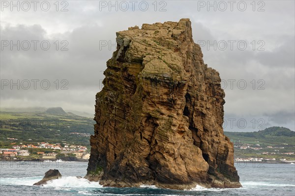 Imposing rock monolith 'Iieu em Pe' stands in the Atlantic Ocean off the coast of the island of Pico with the town of Madalena in the background, Iieu Deitado, Iieu em Pe, Horta, Faial, Azores, Portugal, Europe