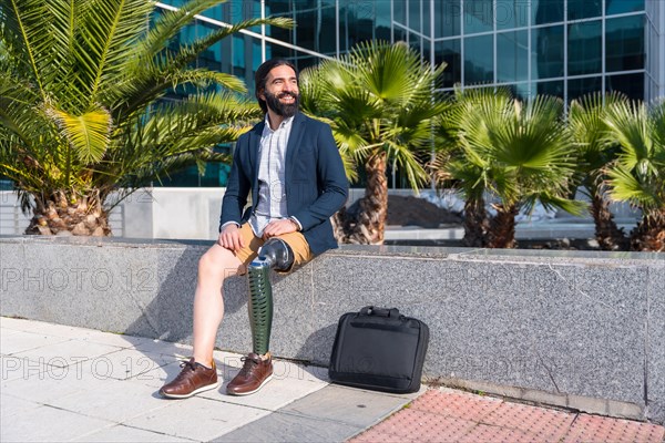 Businessman with prosthetic leg sitting outside a financial building in a sunny day in the city