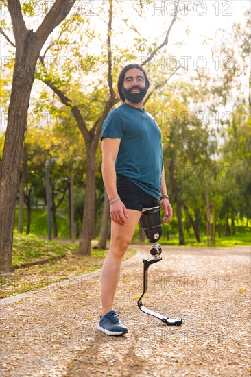 Portrait of a sportsman with prosthetic leg smiling at camera outdoors