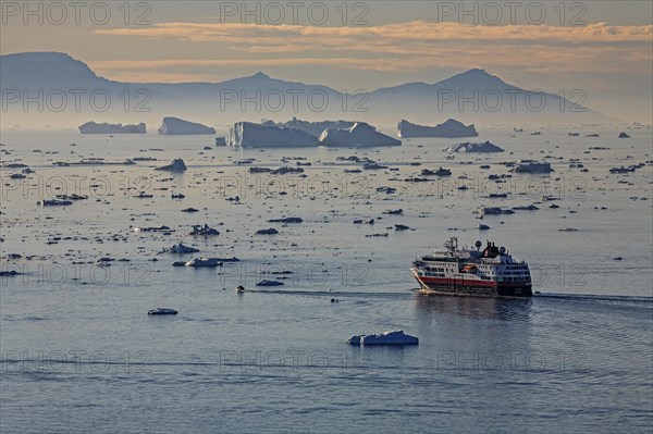 Hurtigruten ship in front of icebergs, reflection, midnight sun, summer, Ilulissat Icefjord, Disko Bay, Greenland, North America