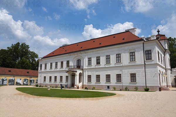 Baroque castle with a red roof and white facade surrounded by a well-tended garden, Esterhazy Castle, Tata, Totis, Lake Oereg, Komarom-Esztergom, Central Transdanubia, Hungary, Europe