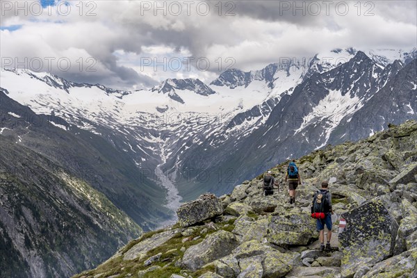 Mountaineer on hiking trail, view of glaciated rocky mountain peaks Hoher Weisszint and Hochfeiler with glacier Schlegeiskees, Berliner Hoehenweg, Zillertal Alps, Tyrol, Austria, Europe