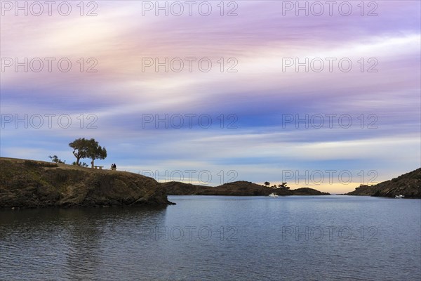 Couple enjoying a picturesque sunset in winter, bay on the Cap de Creus peninsula, Portlligat, Port Lligat, Costa Brava, Cadaques, Girona, Catalonia, Spain, Europe