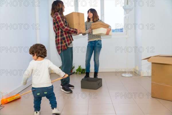 Lesbian couple talking while and a little girl playing around while move