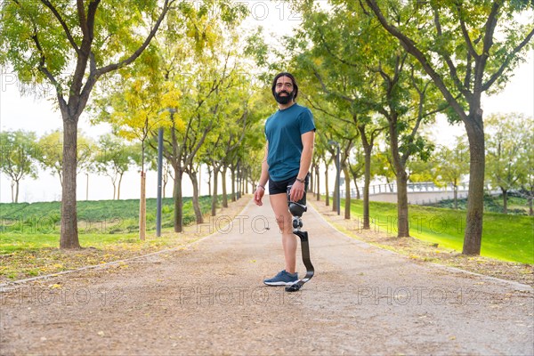 Portrait with wide view and copy space of a runner with a artificial leg standing outdoors