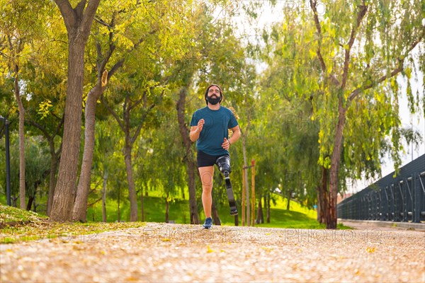 Low angle view photo with copy space of a disabled athletic man running with prosthetic leg in a park